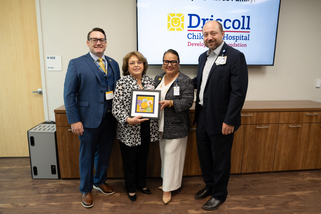 four people stand in a photo celebrating a donation