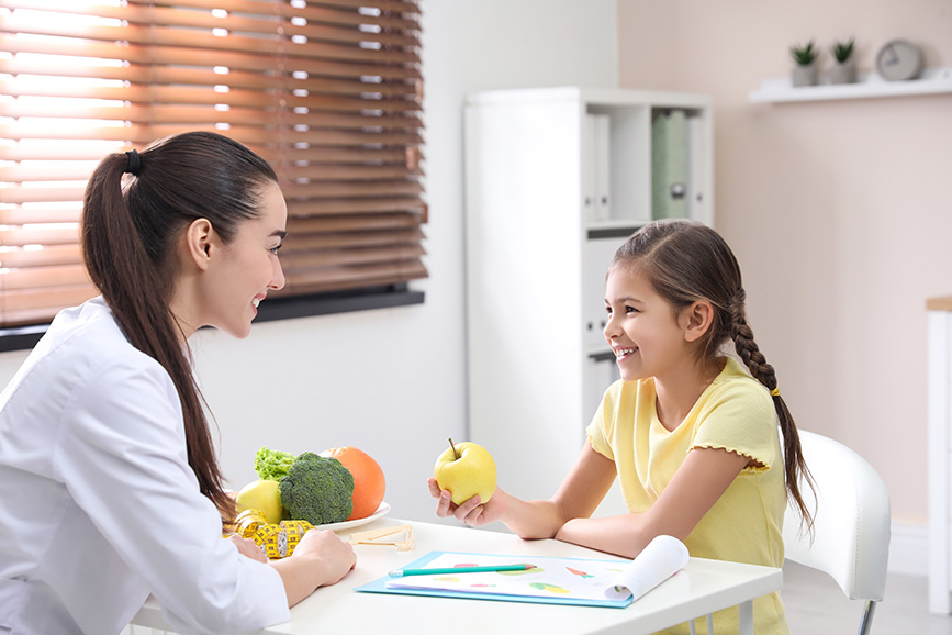 Pediatrician talking to a girl about nutrition.